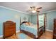 Bedroom with a four-poster bed, light blue walls, hardwood floors and a ceiling fan at 517 Wheddon Cross Way, Wake Forest, NC 27587