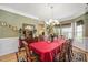 Charming dining room featuring a large chandelier, hardwood floors, and ample seating at 517 Wheddon Cross Way, Wake Forest, NC 27587