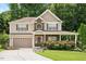 Traditional two-story home with stone accents, attached garage, and meticulously maintained lawn and plantings at 517 Wheddon Cross Way, Wake Forest, NC 27587