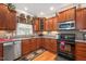 Well-lit kitchen showcasing wood cabinets, granite countertops, and stainless steel appliances at 517 Wheddon Cross Way, Wake Forest, NC 27587