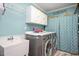 Well-organized laundry room with front-loading machines, sink, cabinets, and stylish decor at 517 Wheddon Cross Way, Wake Forest, NC 27587