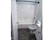 Bathroom features a combined shower and tub, tiled floors, and white vanity with an open toilet seat at 5228 Olive Rd, Raleigh, NC 27606