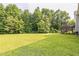 Expansive backyard with lush lawn and mature trees provides ample space for recreation at 54 Lockwood Dr, Clayton, NC 27527