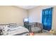Bedroom with a queen bed, crib, TV, and blue curtain and neutral carpeting at 54 Lockwood Dr, Clayton, NC 27527
