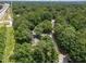 An aerial view displays the property near highway and a city in the distance, set in a lush, green neighborhood at 5520 Kaplan Dr, Raleigh, NC 27606