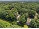 An aerial view showcases the property nestled in a lush, green neighborhood with mature trees and power lines at 5520 Kaplan Dr, Raleigh, NC 27606