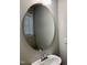 Bright bathroom features a modern sink, oval mirror, and natural light from the window at 656 Barneswyck Dr, Fuquay Varina, NC 27526