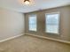Bright bedroom featuring neutral walls, carpeting, and two windows, creating a serene atmosphere at 656 Barneswyck Dr, Fuquay Varina, NC 27526