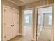 Hallway with neutral walls, carpet, and doors leading to multiple rooms, offering a glimpse of natural light at 656 Barneswyck Dr, Fuquay Varina, NC 27526