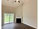 Bright living room featuring fireplace, high ceilings, and sliding door access to backyard at 656 Barneswyck Dr, Fuquay Varina, NC 27526