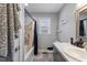 Bathroom with single sink vanity, shower-tub combo, grey walls, and window at 729 Carolina Dr, Dunn, NC 28334