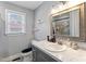 Bathroom features single sink vanity, toilet, tile floors, and window at 729 Carolina Dr, Dunn, NC 28334