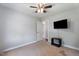 Neutral bedroom with ceiling fan, television, and doorway leading to another room at 729 Carolina Dr, Dunn, NC 28334