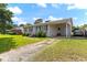 View of single story white brick home featuring a covered carport and driveway at 729 Carolina Dr, Dunn, NC 28334