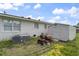 View of the home exterior with white brick, backyard shed, and lawn mower at 729 Carolina Dr, Dunn, NC 28334