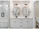 Elegant bathroom featuring a double vanity with rectangular mirrors, modern lighting, and a glass-enclosed shower at 80 Birchtop Cir, Zebulon, NC 27597