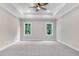 Spacious bedroom with tray ceiling, ceiling fan, and two windows providing ample natural light at 80 Birchtop Cir, Zebulon, NC 27597