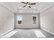 Spacious bedroom with neutral paint, plush carpet, ceiling fan, and two windows providing ample natural light at 80 Birchtop Cir, Zebulon, NC 27597