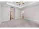Large bedroom boasts tray ceilings, carpeted floor, a ceiling fan, and access to other rooms at 80 Birchtop Cir, Zebulon, NC 27597