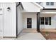 Welcoming front entrance featuring a glass door, black columns, and manicured landscaping at 80 Birchtop Cir, Zebulon, NC 27597