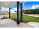 Covered front porch with stained pillars and a concrete floor overlooks a tree-lined lot at 80 Birchtop Cir, Zebulon, NC 27597