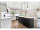 Modern kitchen with white cabinets, a contrasting black island, and wood floors at 80 Birchtop Cir, Zebulon, NC 27597