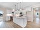 Modern kitchen with white cabinets, center island, stainless steel appliances, and stylish pendant lighting at 80 Birchtop Cir, Zebulon, NC 27597