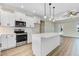 Bright and airy kitchen with white cabinets, center island, and modern appliances; open to living space at 80 Birchtop Cir, Zebulon, NC 27597