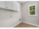 Bright laundry room with overhead cabinets and a window to the backyard at 80 Birchtop Cir, Zebulon, NC 27597