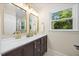 Elegant bathroom featuring dual sinks, a large mirror, and contemporary lighting fixtures at 800 Camden Ave, Durham, NC 27701