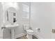 Clean, bright bathroom featuring a pedestal sink and modern toilet at 857 Whistable Ave, Wake Forest, NC 27587