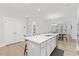 Bright kitchen island with stainless steel sink and seating, with a dining table in an open floorplan at 857 Whistable Ave, Wake Forest, NC 27587
