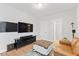 A modern living room boasting hardwood floors, a brown leather couch, and a large TV at 857 Whistable Ave, Wake Forest, NC 27587