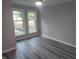 Neutral bedroom with gray walls, gray wood flooring, and two windows offering a view at 911 Washington St # 102, Raleigh, NC 27605