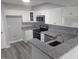 Modern kitchen featuring white cabinets, granite countertops, stainless steel appliances, and gray flooring at 911 Washington St # 102, Raleigh, NC 27605