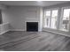 Bright living room showcasing a fireplace, large windows, gray walls, and wood flooring at 911 Washington St # 102, Raleigh, NC 27605