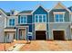 New construction townhomes featuring colorful siding, modern windows, and attached garages at 95 Ripple Way # 212, Clayton, NC 27520