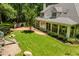 Backyard features a playset, outdoor kitchen, a screened-in porch, and manicured lawn at 100 Donald Dr, Pittsboro, NC 27312