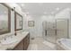 Elegant bathroom features double sinks, a glass-enclosed shower, and a soaking tub at 100 Donald Dr, Pittsboro, NC 27312
