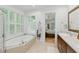 Bright bathroom featuring double vanity, large soaking tub, and window shutters at 100 Donald Dr, Pittsboro, NC 27312