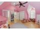 A bright pink bedroom features hardwood floors, a bookshelf, and a closet at 100 Donald Dr, Pittsboro, NC 27312