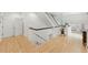 Bright hallway with hardwood floors leading to bedrooms and a spacious landing area at 100 Donald Dr, Pittsboro, NC 27312