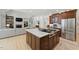 Open-concept kitchen with island cooktop flows into the living room with fireplace, and hardwood floors at 100 Donald Dr, Pittsboro, NC 27312