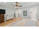 Bright bedroom features hardwood floors, white walls, a ceiling fan, and closet access at 100 Donald Dr, Pittsboro, NC 27312