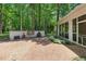 Brick patio with outdoor cooking area and screened-in porch surrounded by lush landscaping at 100 Donald Dr, Pittsboro, NC 27312