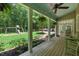 Relaxing porch with seating, ceiling fan, overlooking lush backyard with play set at 100 Donald Dr, Pittsboro, NC 27312