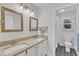 Bright bathroom features double sinks with granite countertops and wood-framed mirrors at 100 Windvale Ct, Cary, NC 27518
