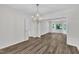 Open dining room with hardwood floors, a stylish chandelier, and adjacent living room at 100 Windvale Ct, Cary, NC 27518