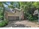 View of a two story home with an attached two-car garage, brick chimney, and an American flag at 100 Windvale Ct, Cary, NC 27518