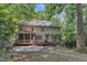 Rear exterior of home featuring a screened-in porch, deck, patio and lush trees at 100 Windvale Ct, Cary, NC 27518